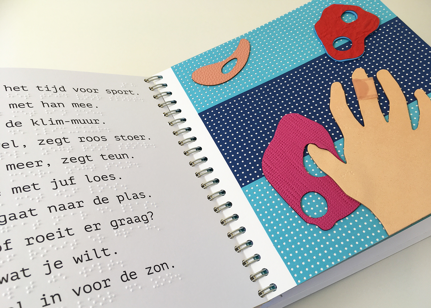 Dubbele pagina met links het verhaal en rechts een tactiele illustratie van een hand op een klimmuur.