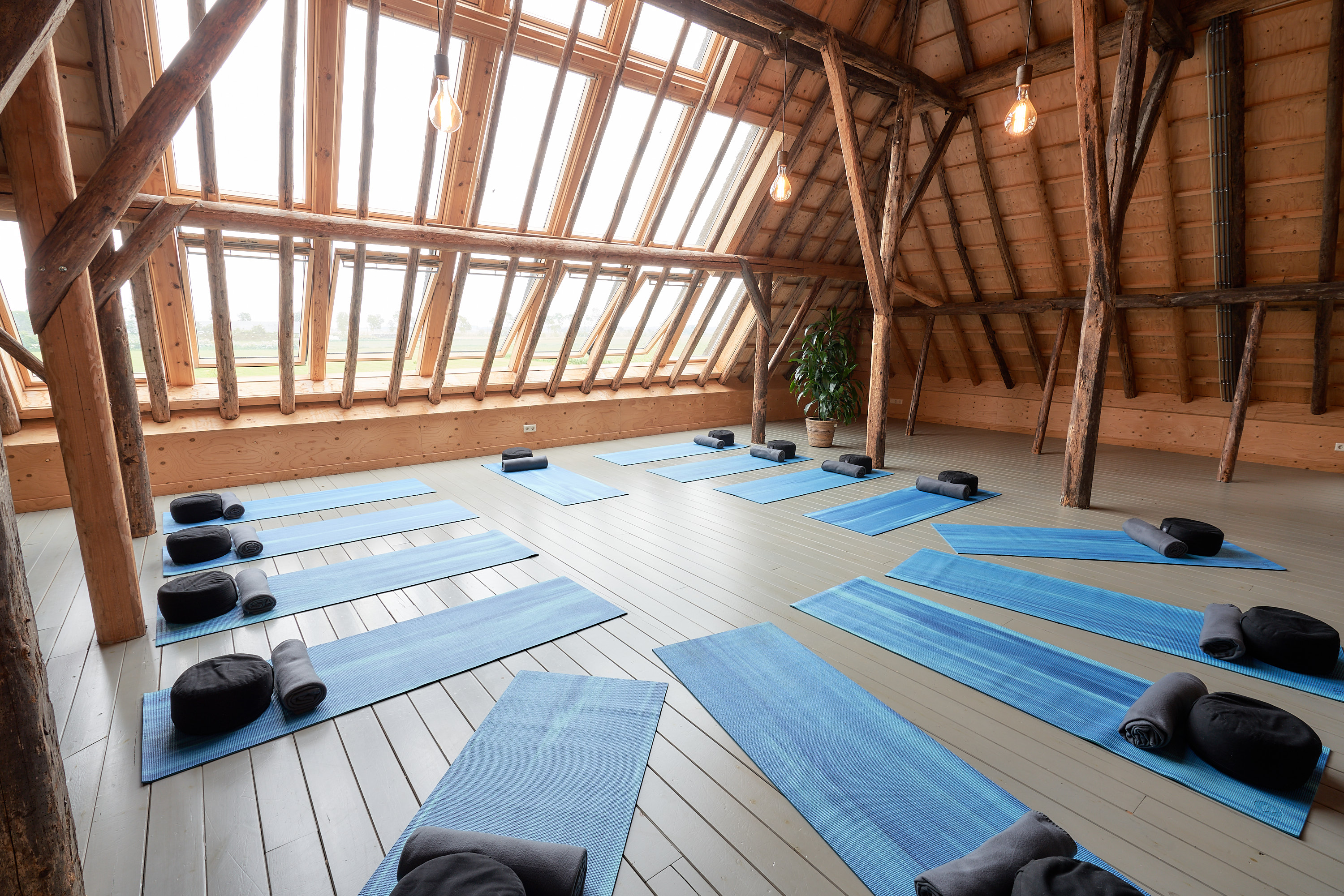 De vide met grote raampartij en yogamatten op de grond.